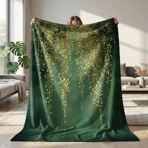 May include: A rectangular throw blanket featuring a deep forest green background with a cascading pattern of shimmering gold floral vines. The design includes clusters of small, glowing golden dots that resemble hanging blossoms or sparkling lights.