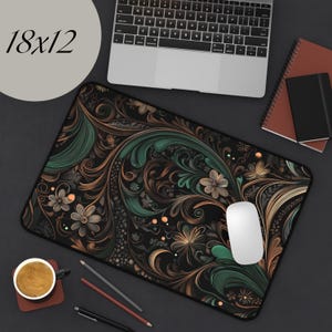 May include: A black mouse pad with a green and gold floral pattern. The mouse pad is 18 inches by 12 inches.