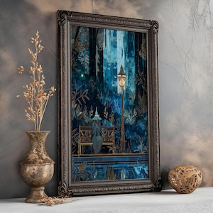 Op de afbeelding: Ingelijste kunstdruk met een persoon in een blauwe jurk en hoed die op een bank onder een lantaarnpaal in een bos zit. Het kunstwerk heeft blauwe en gouden tinten, met een donkere, sierlijke lijst. Een vaas met gedroogde bloemen en een decoratieve bol staan op de voorgrond.