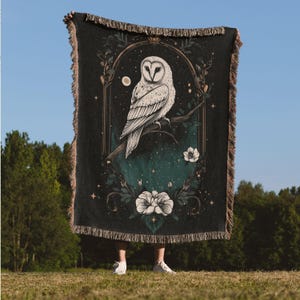 May include: A black woven tapestry with a white owl and floral design. The owl is perched on a branch with a moon and stars in the background.