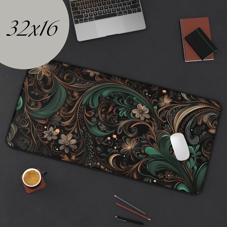 May include: A black and green floral patterned mouse pad with a 32x16 inch size. The mouse pad is on a black surface with a laptop, a cup of coffee, and pencils.