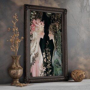 May include: A framed art print featuring two women with floral crowns, one in pink and the other in blue, standing in a lush green forest setting.