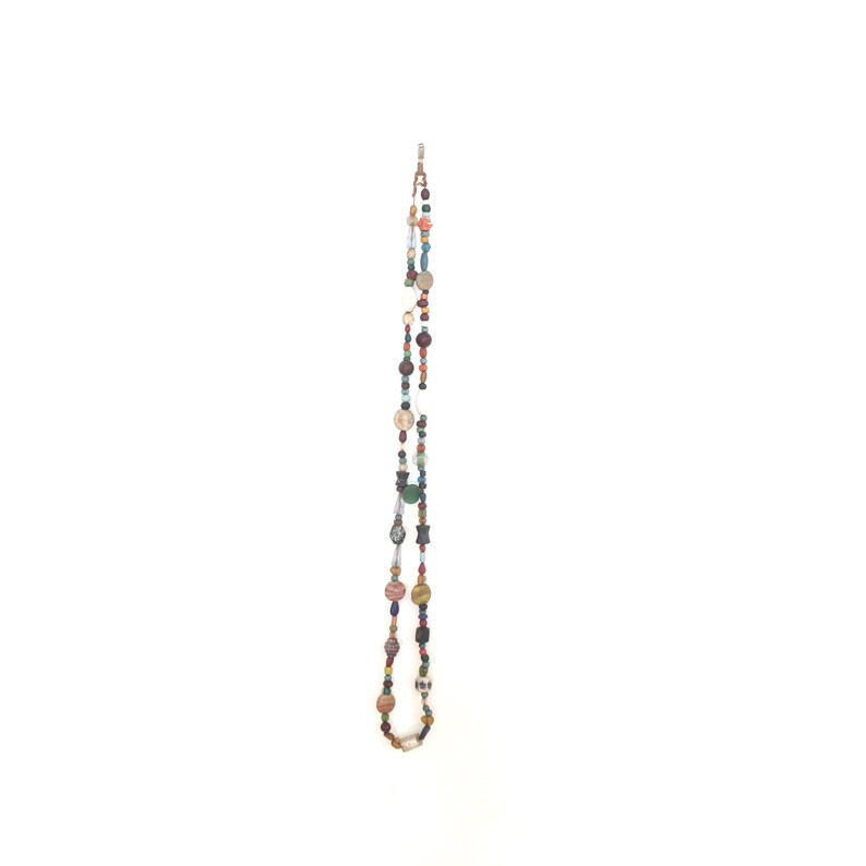 May include: A long beaded necklace featuring a mix of colourful beads, including red, blue, green, and brown.