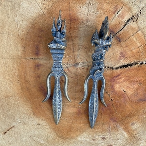 May include: Two ornate, bronze-colored, decorative tridents with intricate designs. The tridents have a three-pronged tip and a detailed, ornate top.