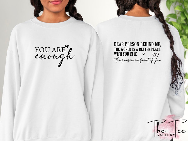 Pu&ograve; includere: Felpa bianca con la scritta "YOU ARE enough" sul davanti e "DEAR PERSON BEHIND ME, THE WORLD IS A BETTER PLACE WITH YOU IN IT. -the person in front of you" sul retro. Scritta nera e dettagli a cuore.