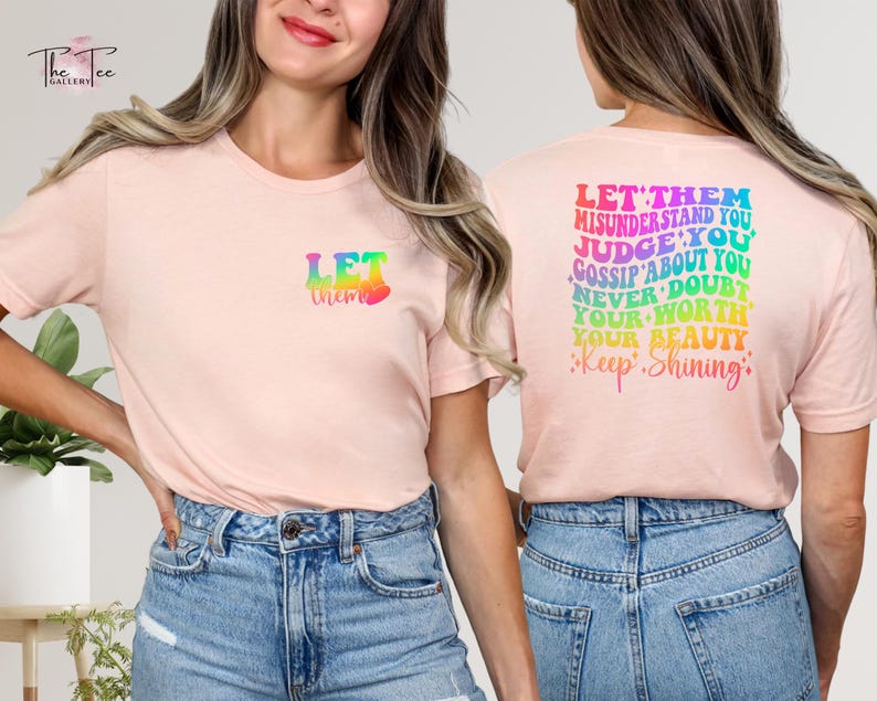 May include: Pink t-shirt with a rainbow graphic that says "Let them" on the front and "Let them misunderstand you, judge you, gossip about you, never doubt your worth, your beauty, Keep Shining" on the back.