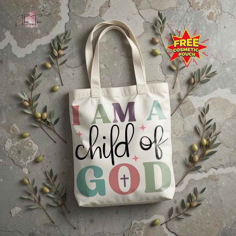 May include: Cream-colored tote bag with the text "I AM A child of GOD" in colorful letters. The bag has two handles and is decorated with olive branches and a "FREE COSMETIC POUCH" sticker.