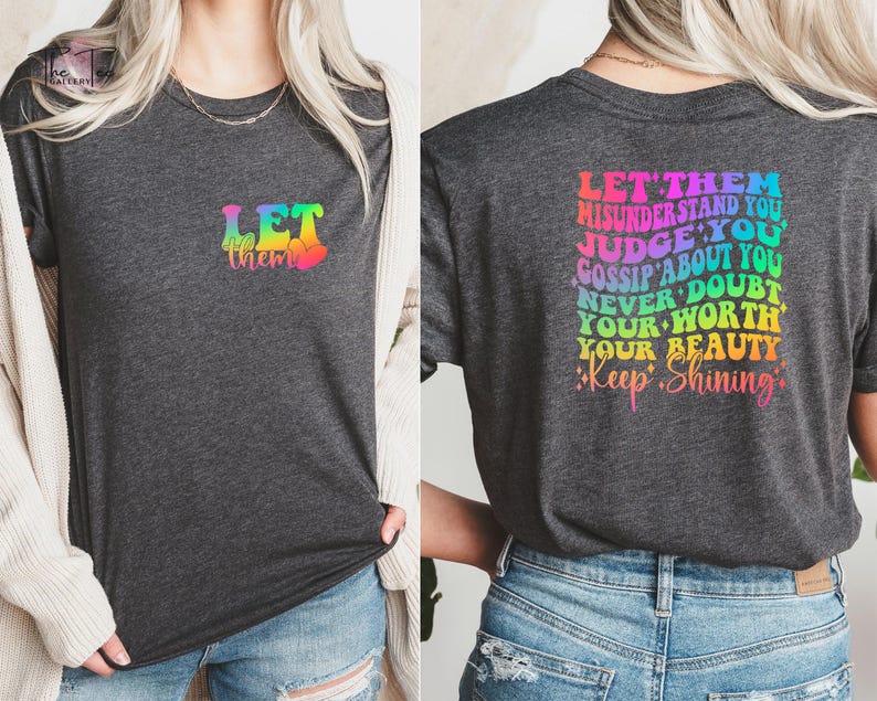 May include: A dark heather grey t-shirt with a rainbow graphic that says "Let them" on the front and "Let them misunderstand you, judge you, gossip about you, never doubt your worth, your beauty, keep shining" on the back.