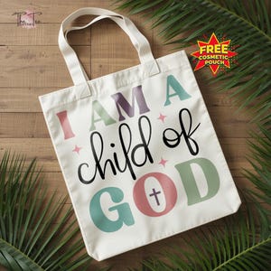 May include: A white tote bag with the text "I AM A child of GOD" in various colors. The bag has a simple design with a cross symbol in the word "GOD". The bag has two white handles.