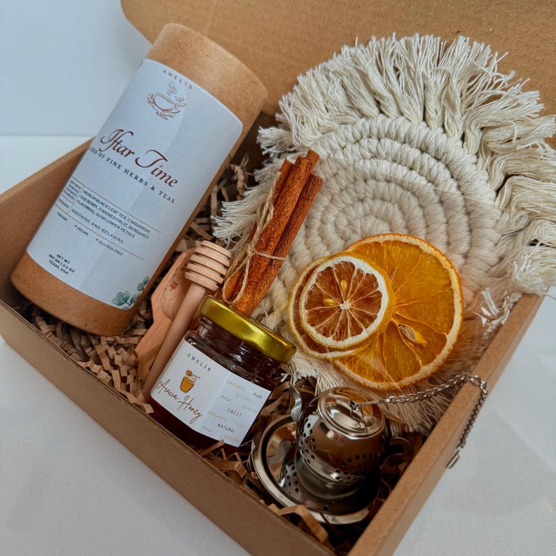 A brown gift box filled with tea and tea accessories