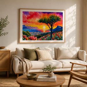 K&ouml;nnte beinhalten: Ein gerahmtes Aquarellgem&auml;lde zeigt einen Sonnenuntergang &uuml;ber einer K&uuml;stenstadt mit einem Baum als Silhouette im Vordergrund. Der Himmel verschmilzt rote, orange und violette Farbt&ouml;ne, w&auml;hrend die Landschaft bunte Blumen und Berge zeigt.