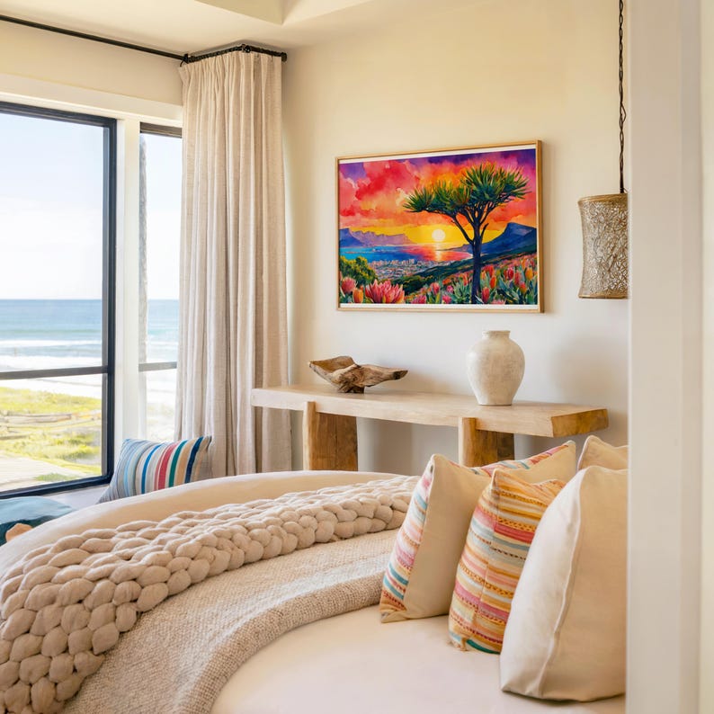 K&ouml;nnte beinhalten: Schlafzimmer-Interieur mit einem lebendigen Landschaftsgem&auml;lde, das einen Sonnenuntergang &uuml;ber einem Berg und einem Baum darstellt. Der Raum umfasst eine Holzkonsolentisch, ein Bett mit einer grob gestrickten Decke und dekorative Kissen. Ein Fenster bietet einen Blick auf das Meer.