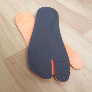 May include: A white ceramic mug with a black handle and the text "But First, Coffee" in a black, bold font. The mug is on a white surface.