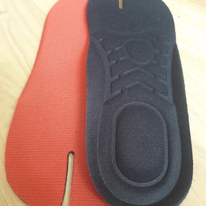 May include: A pair of black and orange tabi socks. The socks are made of a soft, comfortable material and have a split toe design.