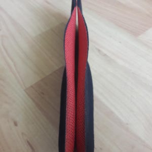 May include: Two black and red insoles for shoes. The insoles are made of a soft, flexible material and have a textured surface.