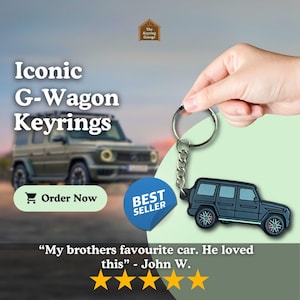 Puede incluir: Un llavero negro de G-Wagon con un llavero plateado. El llavero es un accesorio de coche popular y es un best seller. La imagen también muestra un G-Wagon real en el fondo.