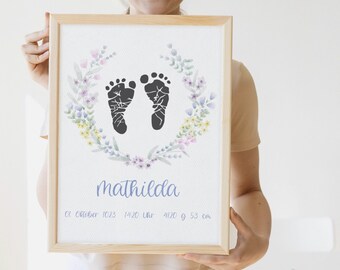 May include: A framed print with a watercolor floral wreath surrounding two black baby footprints. The print includes the name "Mathilda", the date "01 October 2023", the time "14:20 Uhr", the weight "4120 g", and the length "53 cm".