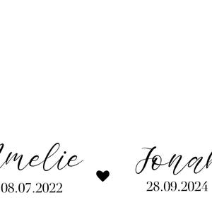 May include: A white background with black text. The text reads "Amelie 08.07.2022" and "Jonah 28.09.2024" with a black heart symbol between the two names.