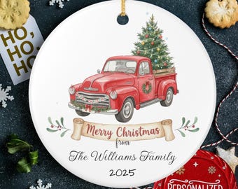 May include: A white ceramic Christmas ornament featuring a red vintage truck carrying a Christmas tree. The ornament has the text "Merry Christmas from The Williams Family 2025".