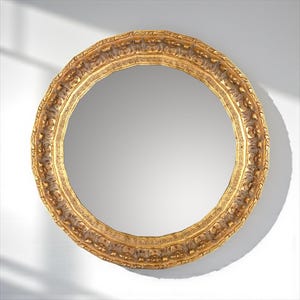 May include: A round, ornate gold mirror with a detailed, textured frame. The frame features intricate carvings and a warm, antique gold finish. The mirror is set against a white background, with a shadow cast across the surface.