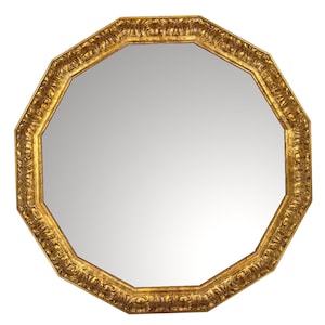 Puede incluir: Espejo octogonal con marco dorado y ornamentado. El marco presenta tallas detalladas y un acabado brillante. La superficie reflectante del espejo es de color gris claro, creando una estética clásica y elegante.