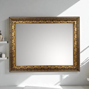 Puede incluir: Un gran espejo rectangular con un marco dorado ornamentado. El marco presenta tallas detalladas y una superficie texturizada. El espejo está montado en una pared blanca, reflejando la habitación. Una pieza decorativa para la decoración del hogar.