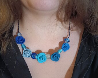 Może przedstawiać: Naszyjnik z niebieskimi i turkusowymi różami z polimerowej gliny i szklanymi koralikami.