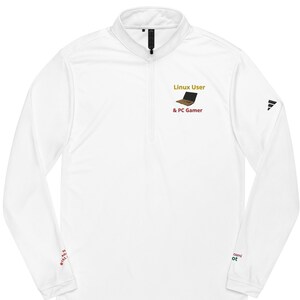 May include: White long-sleeve performance shirt with a zippered collar. The shirt has a gold embroidered design of a laptop with the text "Linux User & PC Gamer".