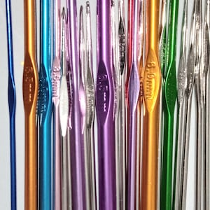 May include: A collection of colorful crochet hooks in various sizes, including 3.5 mm, 3.75 mm, 4 mm, 4.5 mm, 5 mm, 5.5 mm, 6 mm, 6.5 mm, 7 mm, 8 mm, 9 mm, and 10 mm. The hooks are made of metal and have a shiny finish.