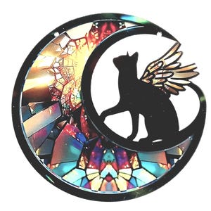 May include: A black cat with wings sits on a crescent moon, set against a backdrop of a stained-glass effect. The circular design features vibrant colours including red, blue, and yellow. The overall design is circular.