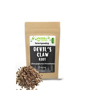 Könnte beinhalten: Ein brauner Papiersack mit der Aufschrift "DEVIL'S CLAW ROOT" und "Premium Grade". Ein Haufen gehackter Wurzelstücke liegt vor dem Beutel. Der Text "Forestgoodsbg" und "100% Natural" sind ebenfalls sichtbar.