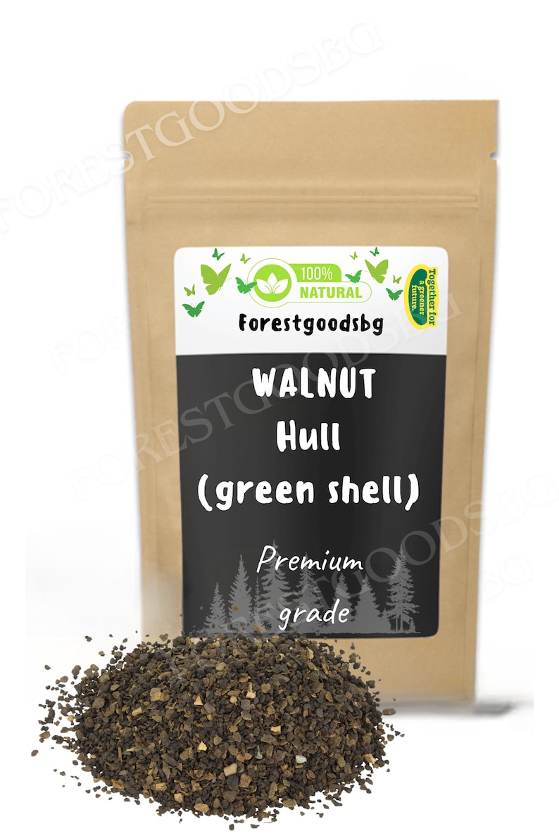 以下が含まれることがあります： Forestgoodsbg、100% Natural、Walnut Hull (green shell)、Premium gradeと書かれた白と黒のラベルが付いた、クルミの殻（緑色の殻）が入った茶色の紙袋。手前には、濃い茶色の粒状のクルミの殻が山積みになっています。