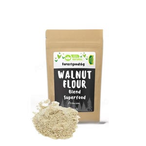以下が含まれることがあります： 黒いラベルに「Walnut Flour Blend Superfood Premium Grade」と緑色のロゴに「100% Natural Forestgoodsbg」と書かれた茶色の紙袋。袋の前に、薄い茶色のクルミ粉の山がある。