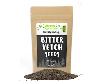 Puede incluir: Una bolsa de papel marrón que contiene semillas de veza amarga, con una etiqueta que dice 100% NATURAL, Forestgoodsbg, BITTER VETCH SEEDS y Premium Grade. Un pequeño montón de semillas oscuras y redondas se extiende frente a la bolsa.