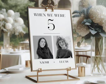 May include: A gold metal table number holder with a white card that says "When we were 5" with black and white photos of a girl and boy. The text below the photos says "Naomi & Lucas".