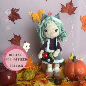 May include: Crochet amigurumi pattern for a girl doll with green hair, wearing a purple sweater and a grey skirt. The doll is holding a basket with apples and a green leaf. The pattern is available as a digital PDF download in English.