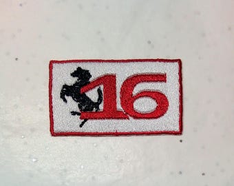 May include: Embroidered patch featuring the number "16" in red, with a black prancing horse logo on a white background. The patch has a red border. The design is rectangular.