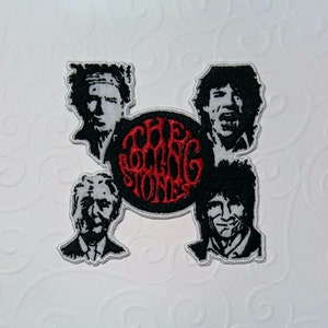 Peut inclure: Écusson brodé représentant quatre portraits en noir et blanc des membres du groupe The Rolling Stones, entourant un logo circulaire rouge et noir avec le nom du groupe. L'écusson a une bordure argentée.