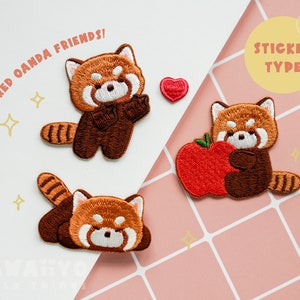 May include: Three embroidered iron-on patches featuring red pandas. The patches are in the shape of red pandas, one holding an apple, one with its arms crossed, and one lying down. The text "RED OANDA FRIENDS!" is in the top left corner of the image. The text "STICKER TYPE" is in the top right corner of the image.