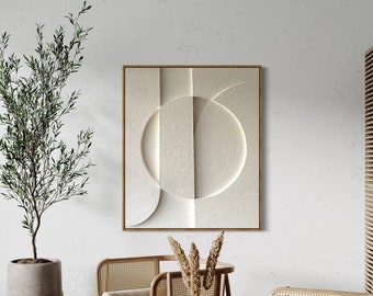 Op de afbeelding: Twee lichtbruine rieten stoelen met een witte tafel ertussen. De stoelen hebben een lichtbruin houten frame en een lichtbruin kussen. De tafel heeft een wit blad en een zilveren onderstel. Er is een witte muur achter de stoelen met een ingelijst abstract kunstwerk aan de muur. Er staat een plant in een pot in de hoek van de kamer.