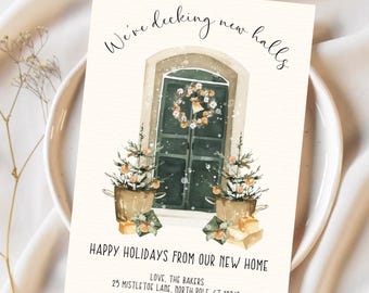 May include: A holiday greeting card with the text "We've decking new halls" above a watercolor illustration of a window with a wreath and two small Christmas trees. The card reads "HAPPY HOLIDAYS FROM OUR NEW HOME".