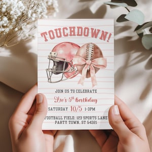 May include: A pink and white football-themed birthday invitation. The invitation features a football helmet and football with a bow, and the text "TOUCHDOWN!" The invitation also includes the party details: Liv's 5th Birthday, Saturday 10/5, 1-3PM.