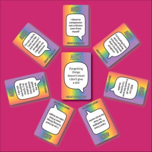 May include: ADHD affirmation cards with rainbow borders and various phrases in speech bubbles, arranged on a pink background. Text includes "Forgetting things doesn't mean I don't give a shit." The cards are for self-care.