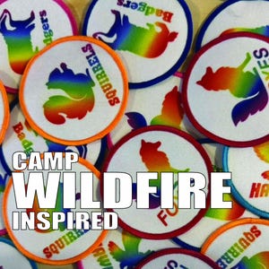 May include: A collection of circular embroidered patches featuring rainbow-coloured animal silhouettes including squirrels, badgers, foxes, and hawks. Each patch has a coloured border and text identifying the animal. The text CAMP WILDFIRE INSPIRED is overlaid.