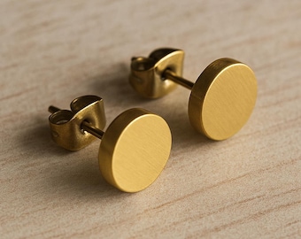 May include: A pair of gold-toned round stud earrings. The earrings are made of metal and have a brushed finish.