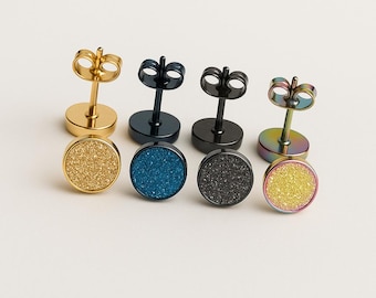 May include: Four pairs of stud earrings in gold, black, blue, and iridescent finishes. Each earring features a round, textured stone set on a post. The earrings are displayed on a white surface.