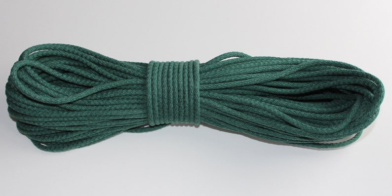 May include: A roll of dark green cotton cord, ideal for crafting projects.