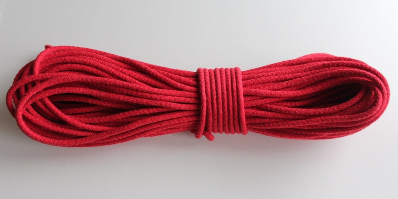 May include: A spool of red cotton cord, ideal for crafting projects.