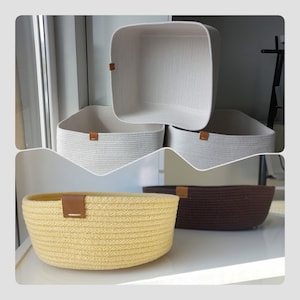 May include: Three woven rope storage baskets in different sizes and colours. The largest basket is white and square, the medium basket is white and round, and the smallest basket is yellow and round.