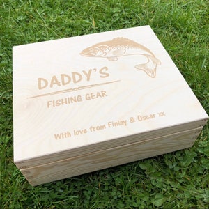May include: A wooden box with the words "Daddy's Fishing Gear" and a fish design engraved on the lid. The box also has the text "With love from Finlay & Oscar xx" engraved on the lid.